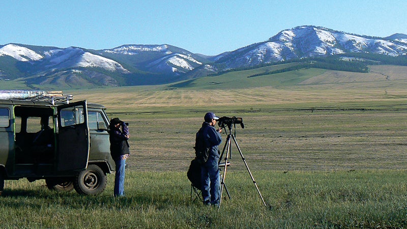 scientists photographing mountain landscape