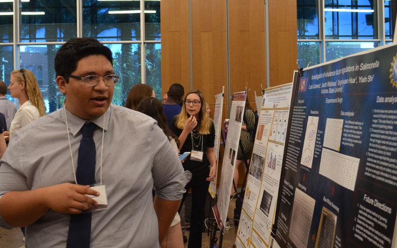 student talking about his research poster