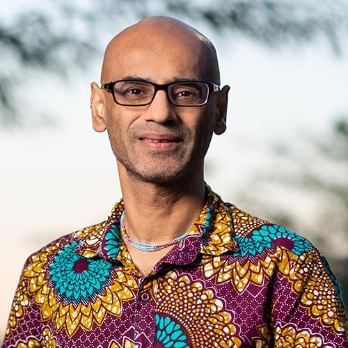 Headshot of Arvind Varsai wearing a maroon, gold and turquoise shirt