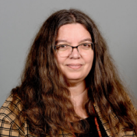 headshot of a woman with glasses and long brown hair